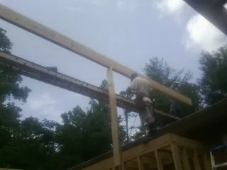 Carpenter setting a ridge beam over a new addition frame — Ice Dam Removal by Roofing Brothers in Sharpsville