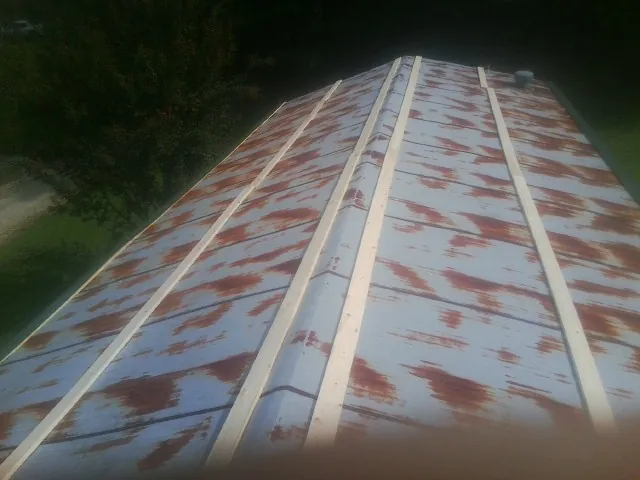 Rusted metal roof panels with new wood purlins before replacement — Storm Damage Roof Repair in Sharpsville by Roofing Brothers