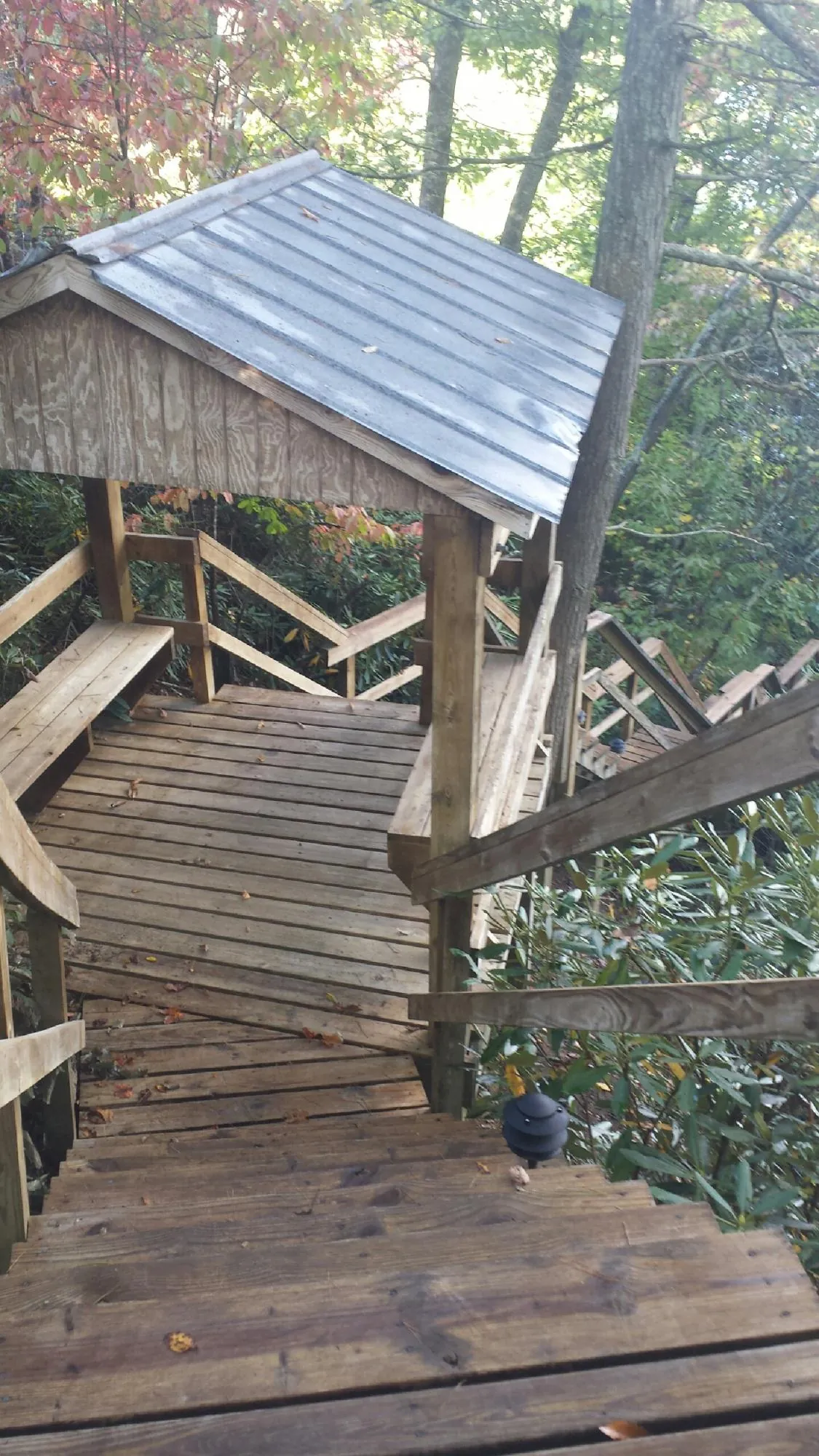 Metal roofed shelter over wooden steps on a wooded walkway — Skylight Repair & Installation work by our crew in Sharpsville