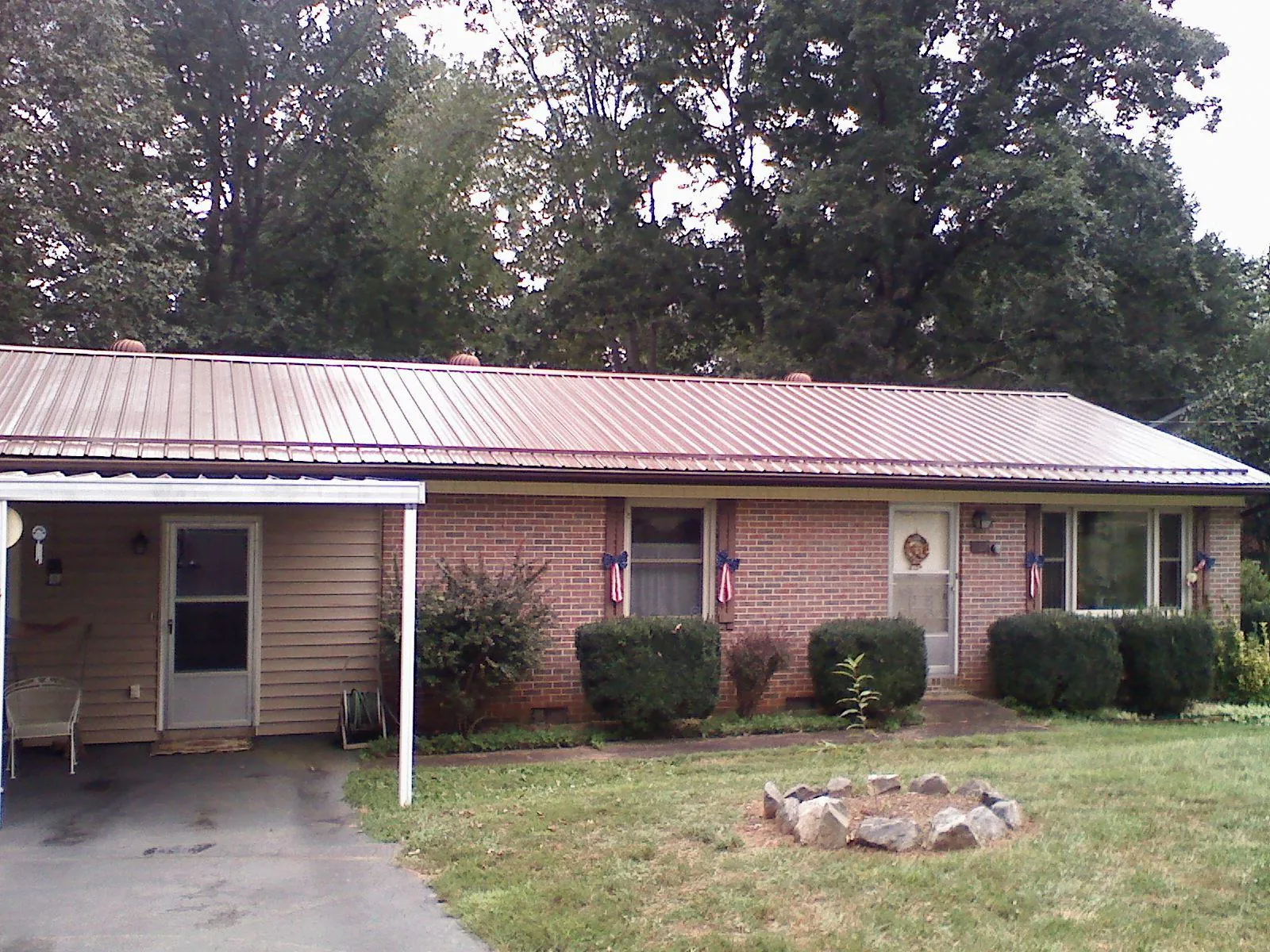 Bronze metal roof and carport on a brick ranch home — Roof Repair work by our crew in Sharpsville