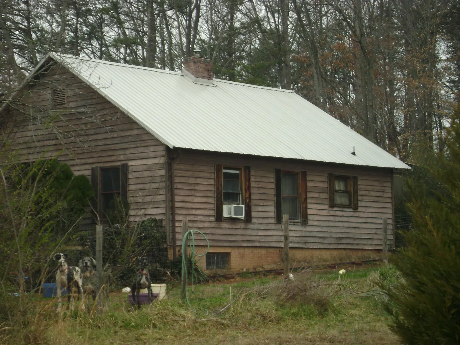 White metal roof on an old wood sided farmhouse, from a Metal Roof Installation job in Sharpsville